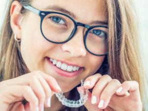 young girl holding Invisalign tray