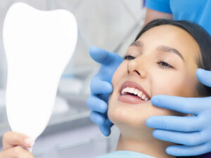 woman in dental chair looking at teeth